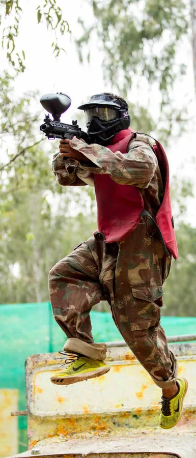 Paintball player in camouflage taking aim