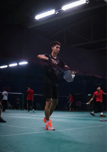 Player smashing a shuttle on the badminton court