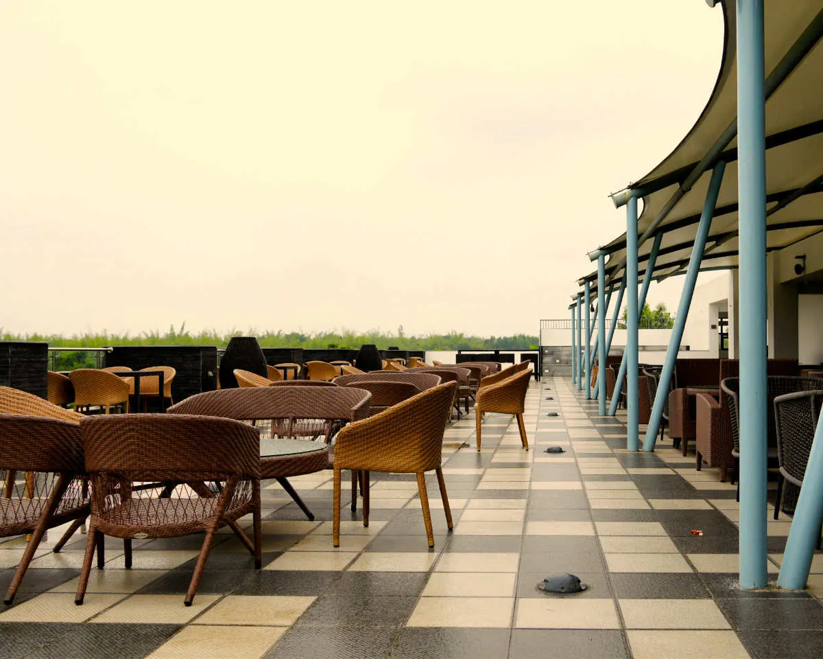 Mist rooftop bar terrace with tables and countryside views