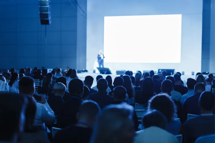 Audience facing a screen at a conference