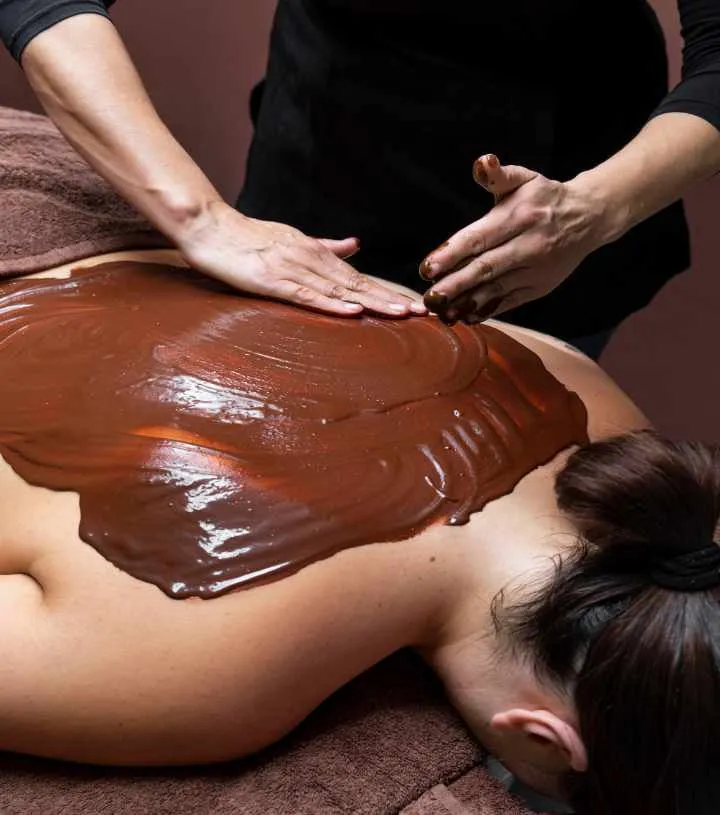 Chocolate body wrap being applied to a guest's back