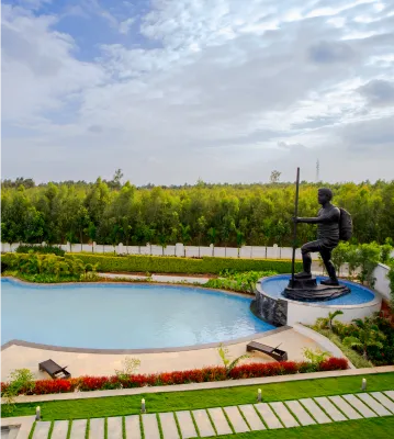 Bronze statue beside the pool with greenery behind
