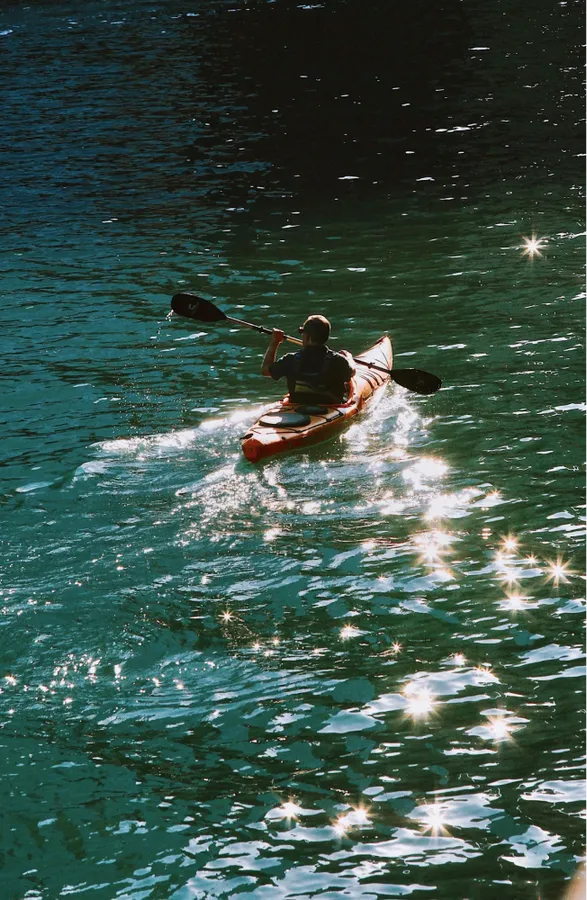 Guest paddling a kayak on the lake