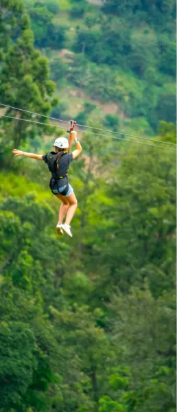 Guest riding the zipline over the trees
