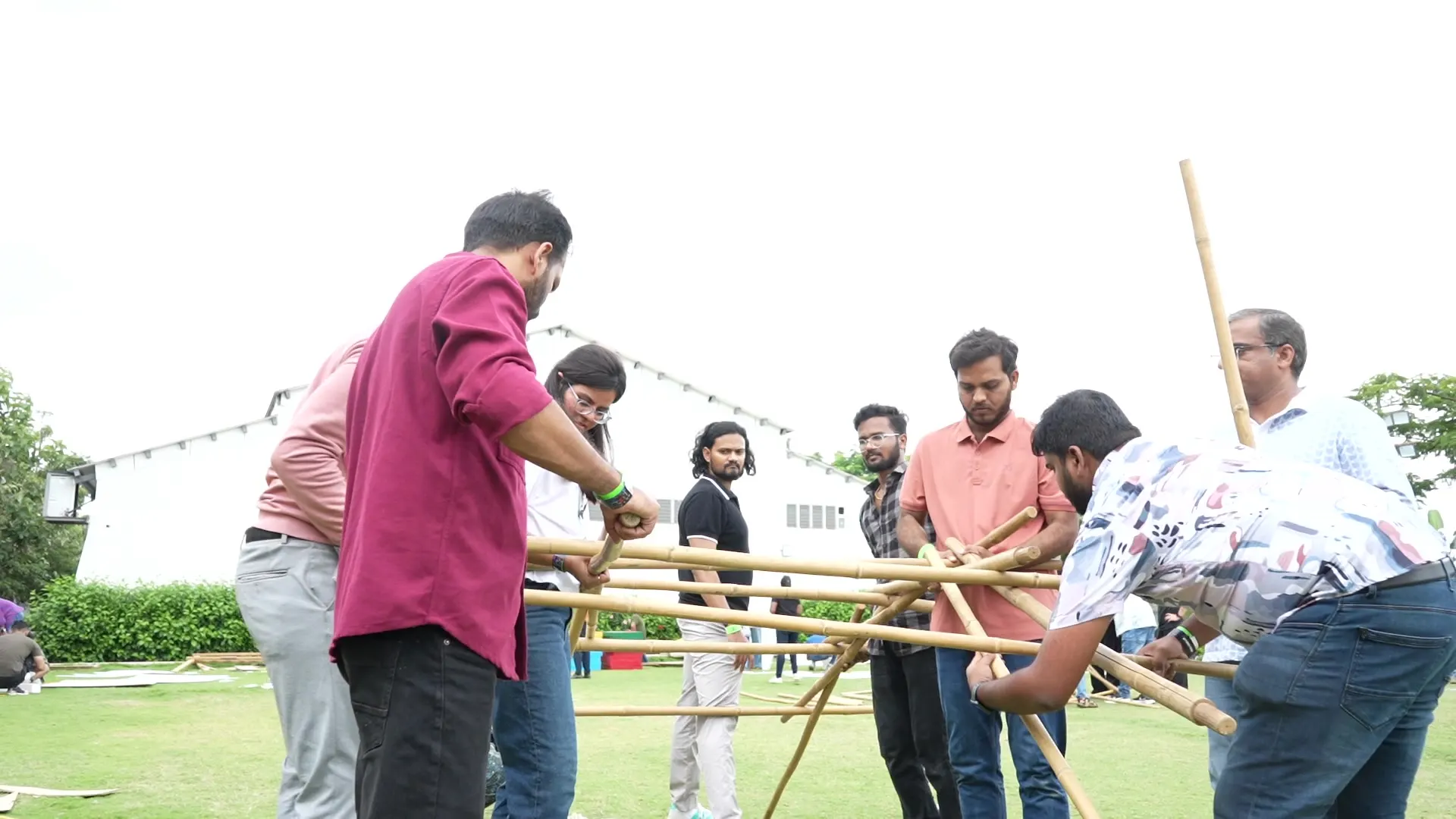 Team holding bamboo poles in a team-building challenge
