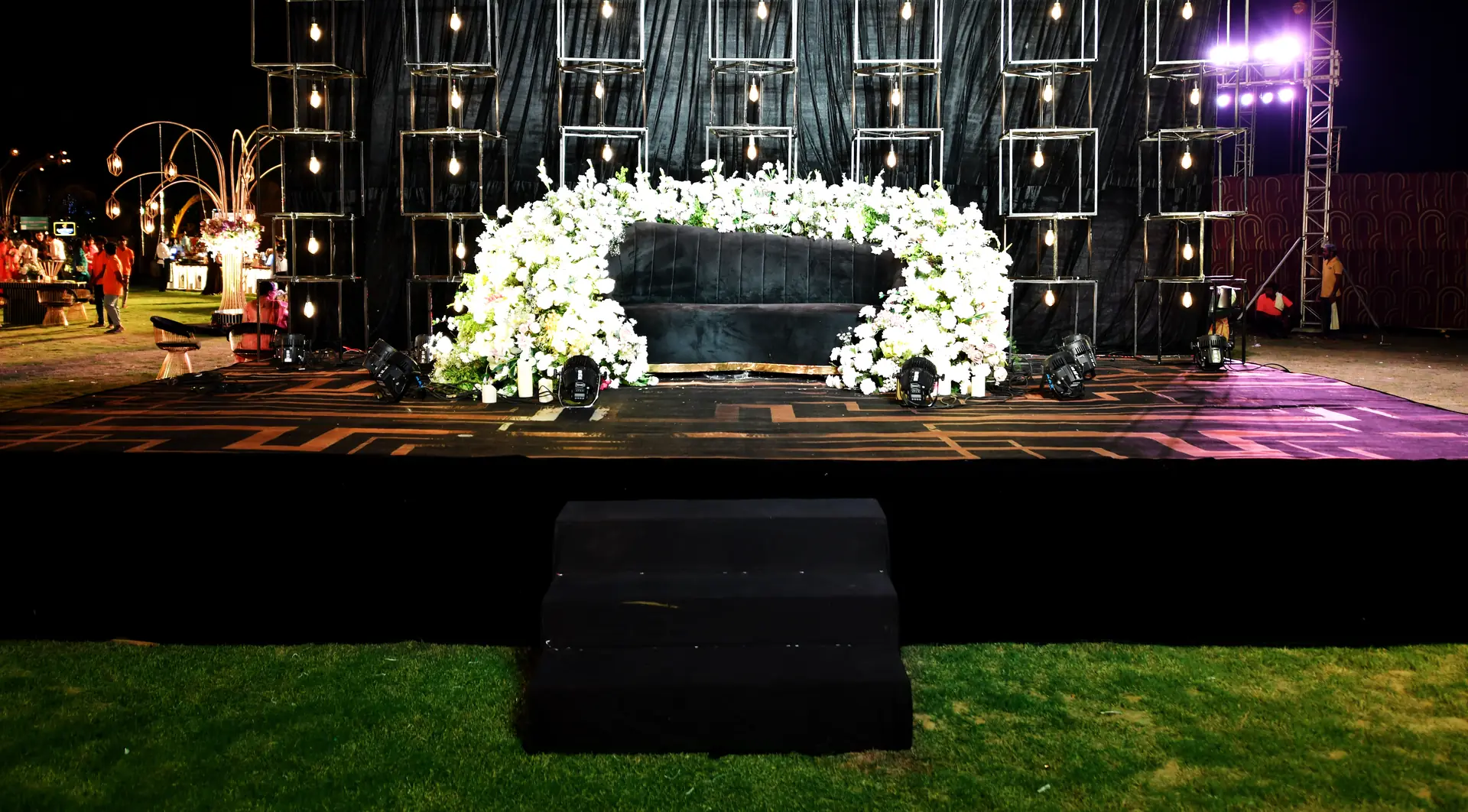 Black stage with white floral décor for a wedding reception