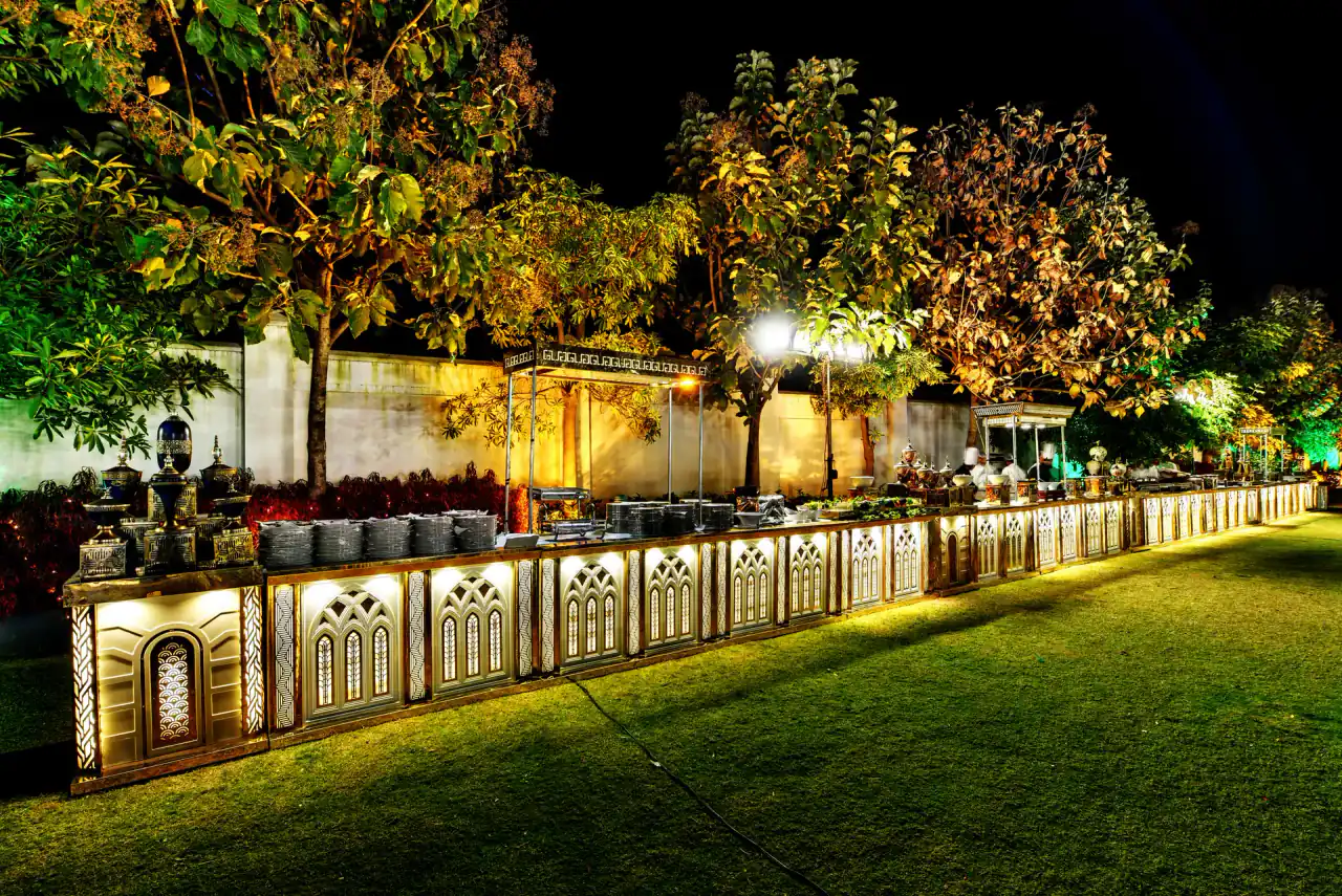 Lit buffet counters on the lawn at night