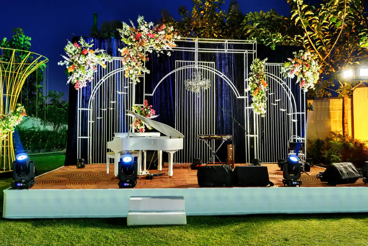 Lit stage on the lawn at night at Sportico Resorts
