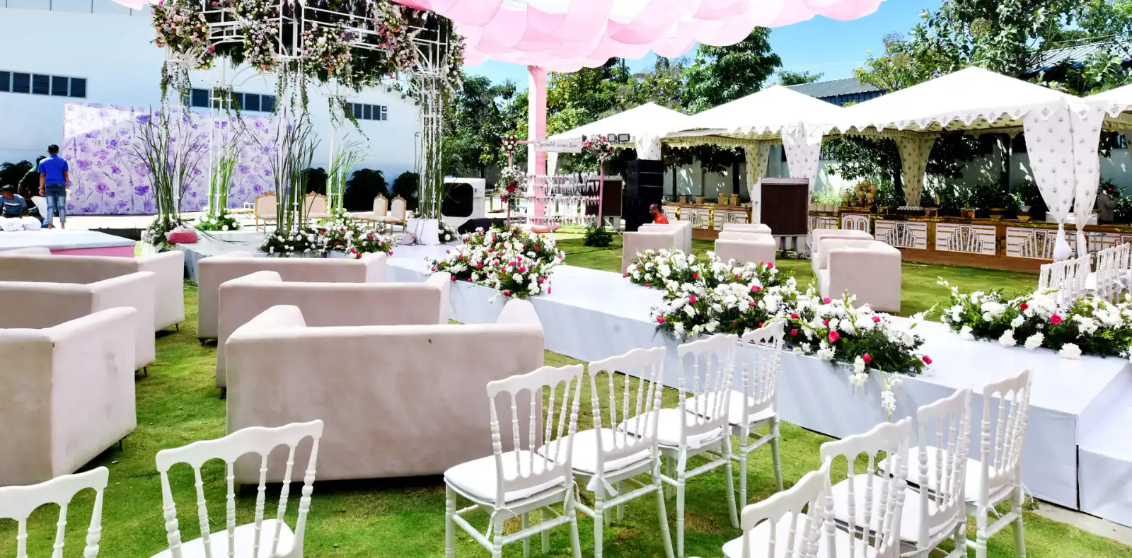 Floral mandap and lounge seating under a pink canopy